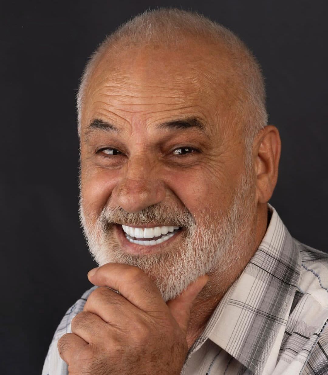 An old man with white teeth smiling thanks to his Dental implants